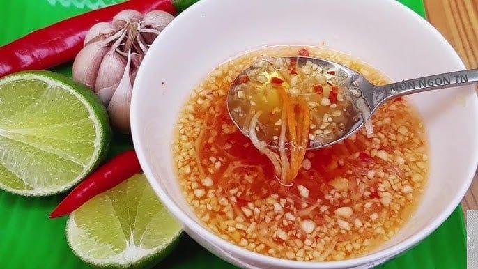 Chén nước mắm chấm chua ngọt với tỏi ớt băm nổi lên trên bề mặt, màu sắc hấp dẫn