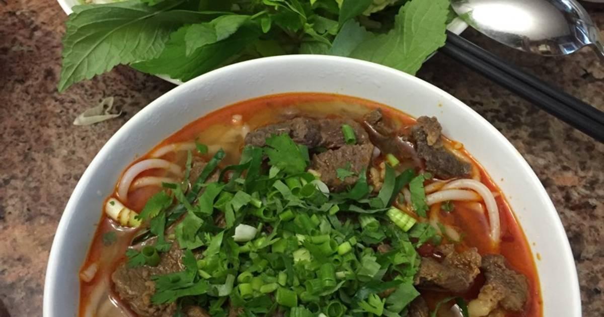 Đĩa rau sống tươi xanh gồm xà lách rau muống chẻ bắp chuối bào giá đỗ và rau thơm ăn kèm món bún riêu chay