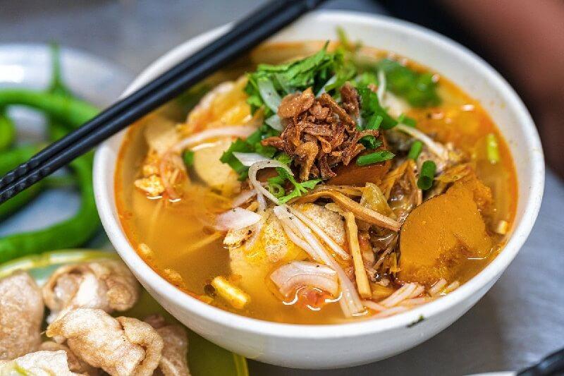 Tô bún chả cá nóng hổi đầy đủ topping chả cá chiên hấp, cà chua, hành lá, chan nước dùng trong